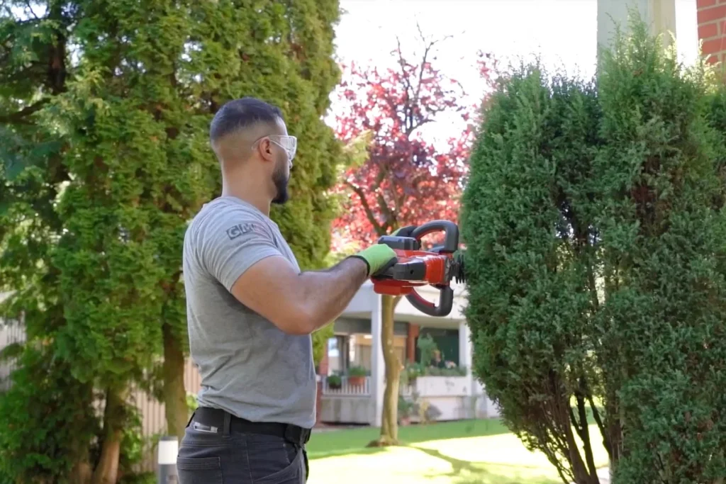 Gartenpflege in Muenster - Mitarbeiter schneidet Hecken